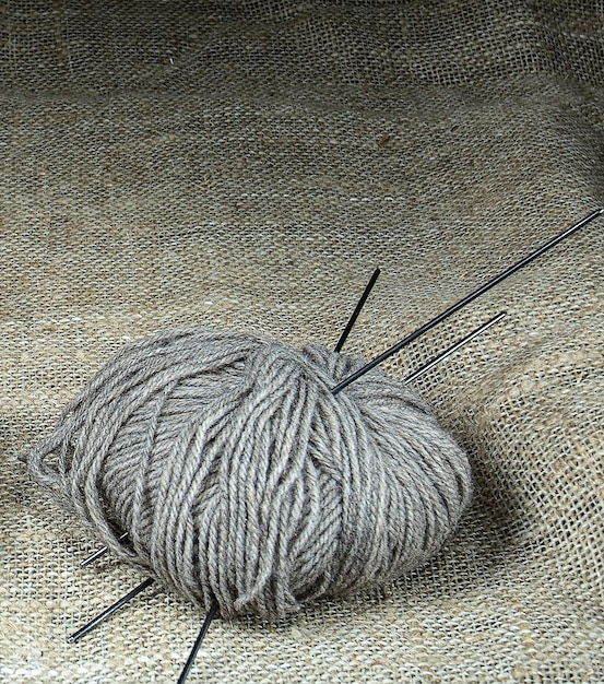 Un símbolo de comodidad en el hogar una bola de hilos de lana para tejer sobre un fondo de arpillera