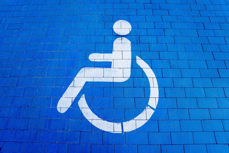 Foto símbolo de deficientes físicos pintado em uma vaga especial de estacionamento para pessoas com deficiência