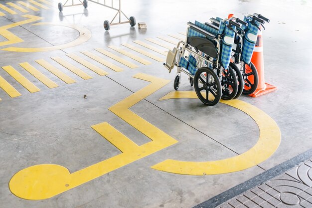 Foto símbolo de handicap na estrada, tráfego e pedestres no espaço de estacionamento