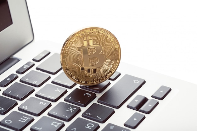 Símbolo de moeda física de bitcoin dourado no teclado