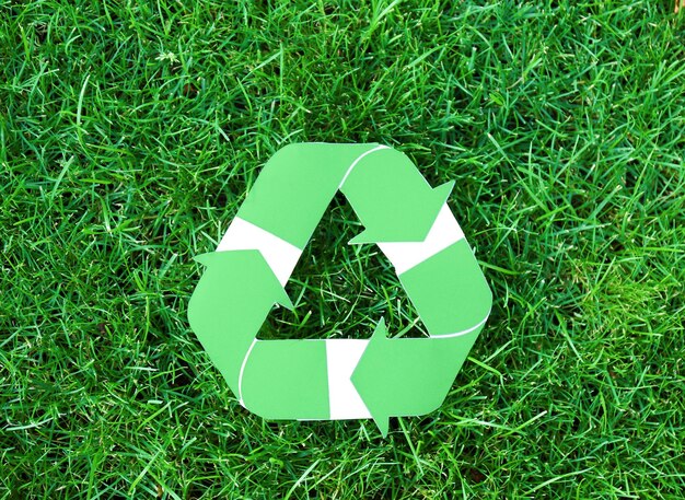 Símbolo de reciclagem na grama verde