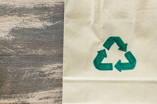 Símbolo de reciclagem verde sobre fundo de papelão, conceito ecológico e sustentável