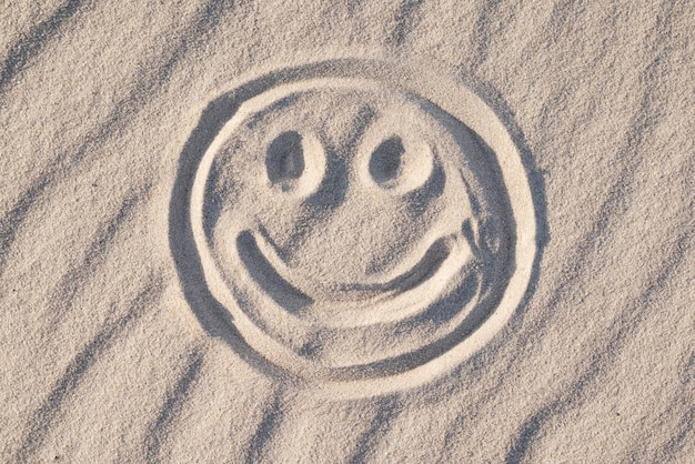 Símbolo de sorriso feliz na areia da praia Felicidade bons sentimentos emoções conceito