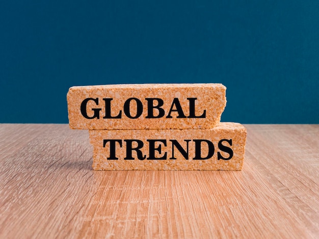 Símbolo de tendências globais Palavras conceituais Tendências globais em blocos de tijolos Belo fundo azul