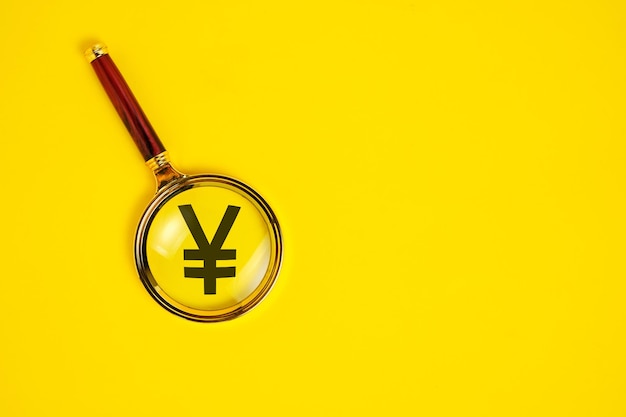 Símbolo de Yuan sob lupa em fundo amarelo