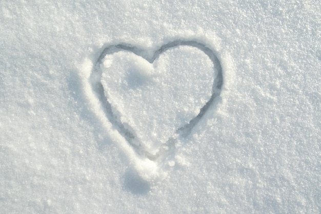 Símbolo do coração desenhado na neve em um dia ensolarado