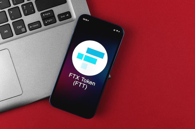 Símbolo do token FTX. Comércio com criptomoeda, dinheiro digital e virtual, bancário com conceito de telefone móvel. Espaço de trabalho de negócios, foto de vista de cima da mesa