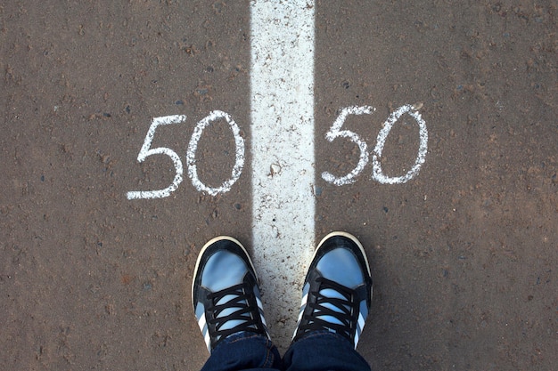 Símbolo de igualdad de género 50/50 sobre asfalto, concepto de género