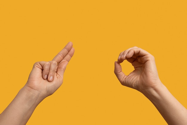 Foto símbolo de lenguaje de señas aislado en amarillo