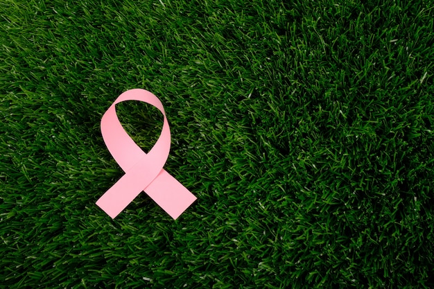 Un símbolo de la lucha contra el cáncer en el espacio de copia de hierba verde.