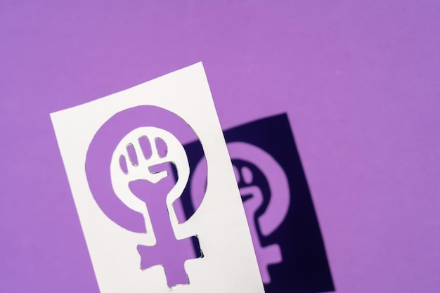 Símbolo de la lucha del feminismo sobre un fondo morado, puño apretado de una mujer en las protestas de marzo por los derechos de las mujeres