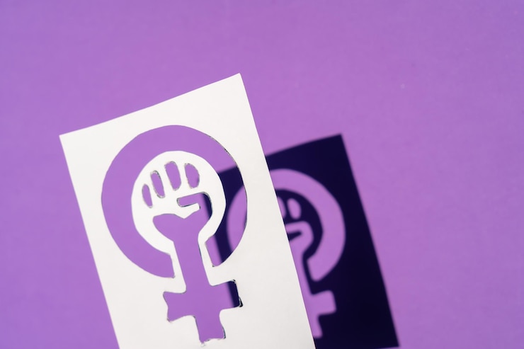 Foto símbolo de la lucha del feminismo sobre un fondo morado, puño apretado de una mujer en las protestas de marzo por los derechos de las mujeres