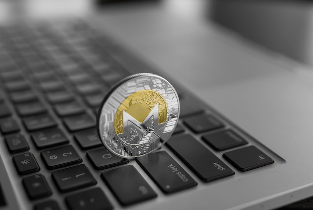 Símbolo de la moneda Monero en la computadora portátil concepto futuro moneda criptográfica signo de moneda financiera