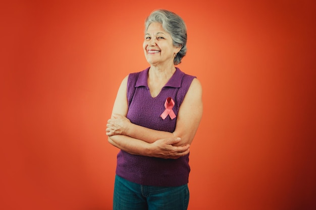 Símbolo de protección contra el cáncer de mama Mujer madura con cinta rosa y camiseta morada aislada para la campaña contra el cáncer de mama