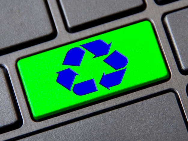 Símbolo de reciclaje en el botón verde del teclado Reutilizar reducir y reciclar