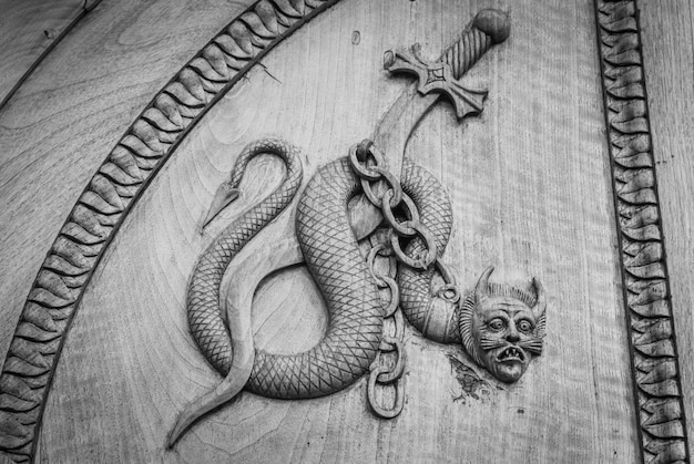 Símbolo de la serpiente del diablo Criatura mágica de fantasía en una puerta antigua Abadía del siglo XII en Italia