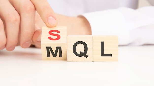 Símbolo SQL ou MQL Empresário vira cubos e muda as palavras 'lead qualificado de marketing MQL' para 'lead qualificado de vendas SQL' Belo fundo branco