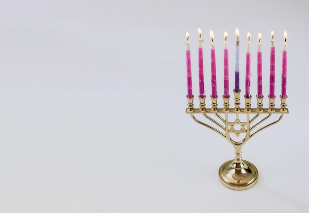 Símbolo tradicional hebreo Menorah de Hanukkah con velas encendidas es para la fiesta judía sobre fondo blanco aislado