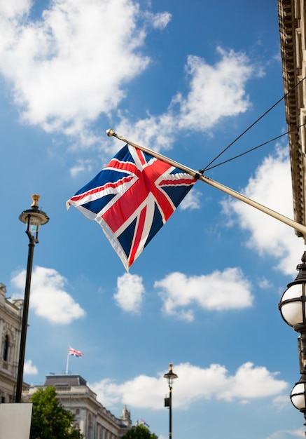 Foto símbolos estatales y concepto de festividades nacionales - bandera británica de nion jack ondeando en la calle de la ciudad de londres