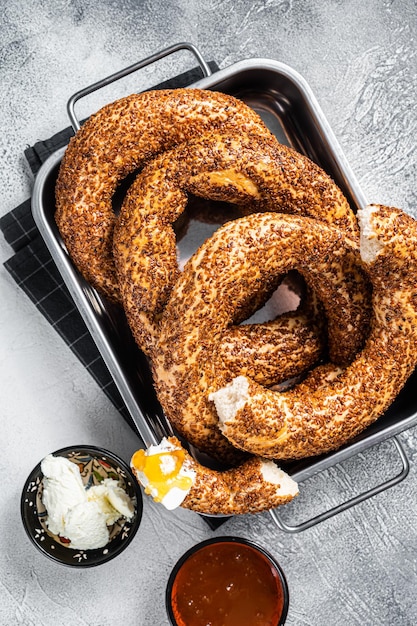 Simit turco casero al horno o bagel Gevrek con kaymak y miel. fondo gris. Vista superior.