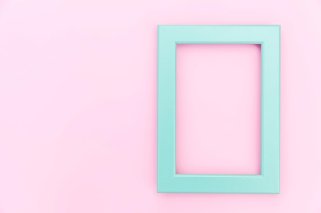Simplemente diseñe con marco azul vacío aislado sobre fondo rosa pastel colorido vista superior plana co ...