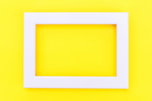 Foto simplemente diseñe con un marco blanco vacío aislado sobre fondo amarillo de moda