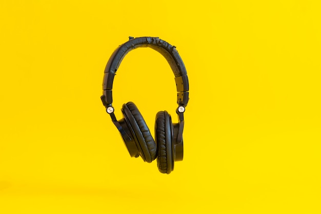 Unos simples auriculares inalámbricos aislados flotando en el aire contra el fondo colorido