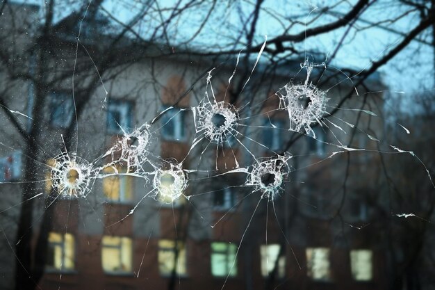 simulación abstracta vista borrosa de los agujeros de bala de la ciudad en el cristal de la ventana, disparando un ataque de fondo de guerra