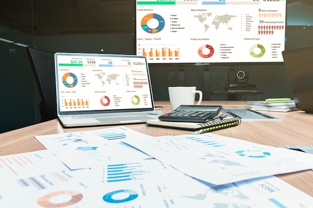 Simulacros de presentación de presentación de diapositivas de resumen de ventas en una computadora portátil con pantalla con calculadora y papeleo en la mesa en la reunión