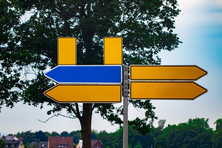 Sinais de trânsito direcionais em branco contra o parque. setas de metal na placa de sinalização.