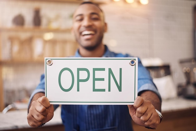 Sinal aberto e close-up do homem na loja da loja e aviso publicitário de placa de tempo de compras de varejo ou informações comerciais Mãos do proprietário do café feliz com banner de abertura de boas-vindas e serviços de inicialização