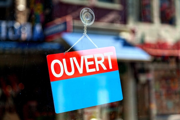 Sinal aberto em francês na vitrine de uma loja