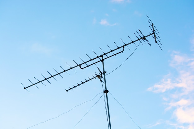 Foto sinal analógico de antenas de televisões (tv) com fundo do céu bluea