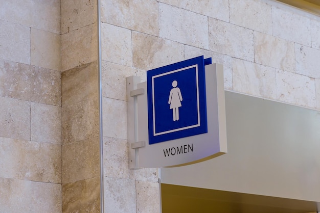 Sinal azul branco quadrado do ícone do banheiro feminino no banheiro com aeroporto terminal