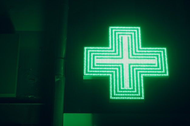 Foto sinal da cruz verde em um prédio de farmácia.