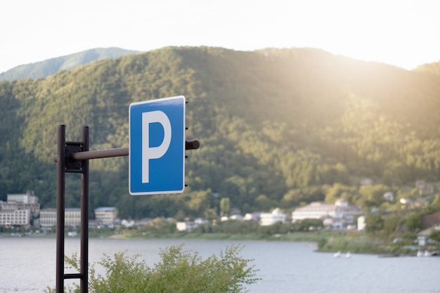 Foto sinal de estacionamento azul com vista para o rio de montanha e pôr do sol