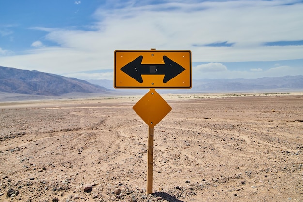 Sinal de estrada à esquerda ou à direita no meio do deserto arenoso