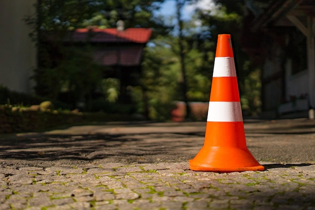 Sinal de estrada de plástico listrado para estacionar na calçada no fundo desfocado Cone de trânsito laranja com duas listras brancas Closeup