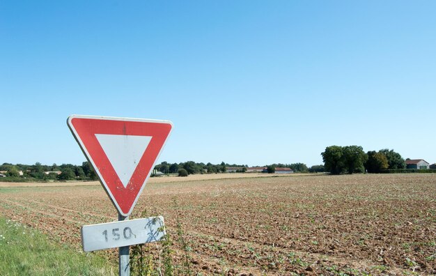 Foto sinal de informação no campo contra um céu azul claro