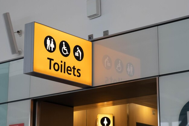 Sinal de luz amarela de banheiros no aeroporto com reflexão