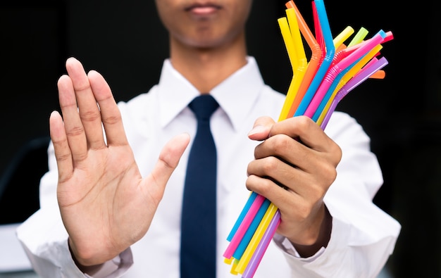 Sinal de mão do empresário dizer não para palhas de plásticas, as pessoas proibir e parar de usar o lixo de plásticos