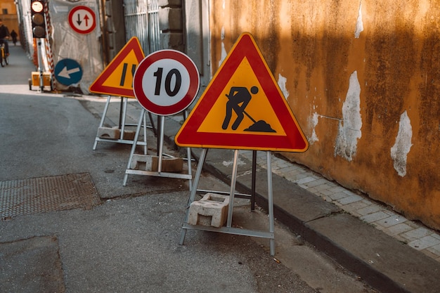 Sinal de obras rodoviárias na estrada Trabalho de reparo de sinais de trânsito e uma seta de desvio em um fundo de céu azul