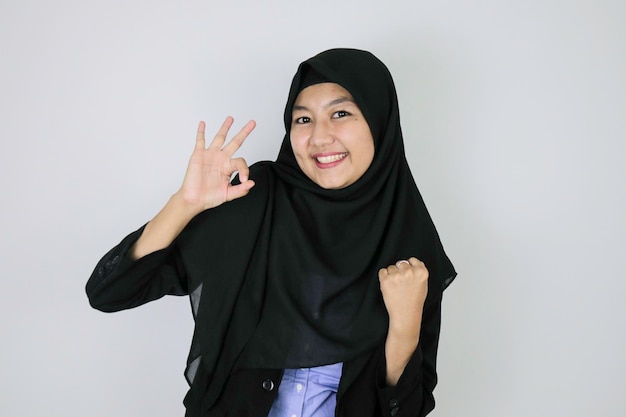 Sinal de ok com sorriso mulheres de negócios islâmicos asiáticos em pé de confiança