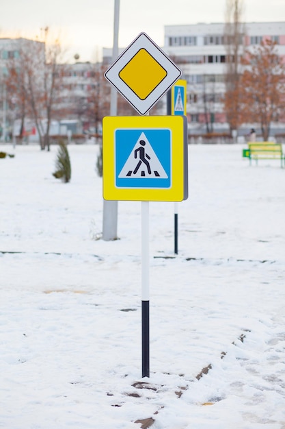 Sinal de trânsito para pedestres e sinal de estrada principal em um parque infantil na Rússia, horário de inverno