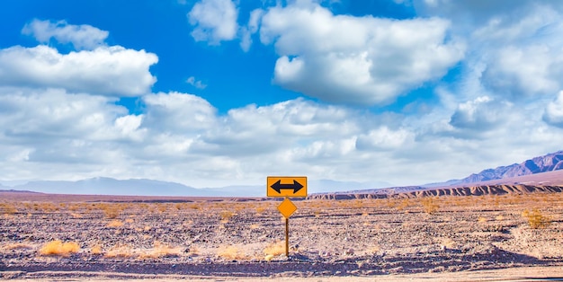 Sinal direcional no deserto com céu azul cênico e amplo horizonte Conceito para liberdade de viagem e transporte