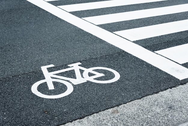 Sinal do caminho para a bicicleta atravessar a rua ao lado da faixa de pedestres