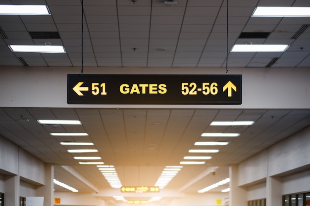 Sinal luminoso amarelo no aeroporto com número de porta para voos de partida