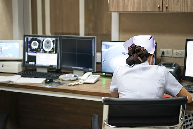 Sinal vital de registro de enfermeira na ficha médica na estação de trabalho de tomografia computadorizada roo