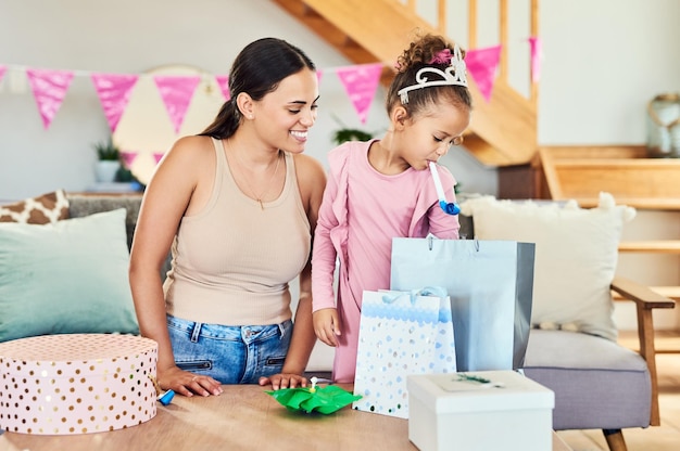 Sind das alles für mich Aufnahme eines kleinen Mädchens, das ihre Geschenke während einer Geburtstagsfeier zu Hause öffnet