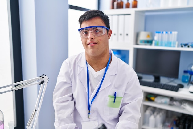 Síndrome de Down hombre vestido con uniforme científico de pie en el laboratorio